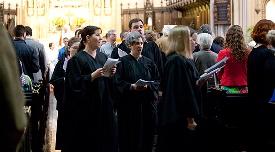 The choir of Emmanuel Music walking through the congregation
